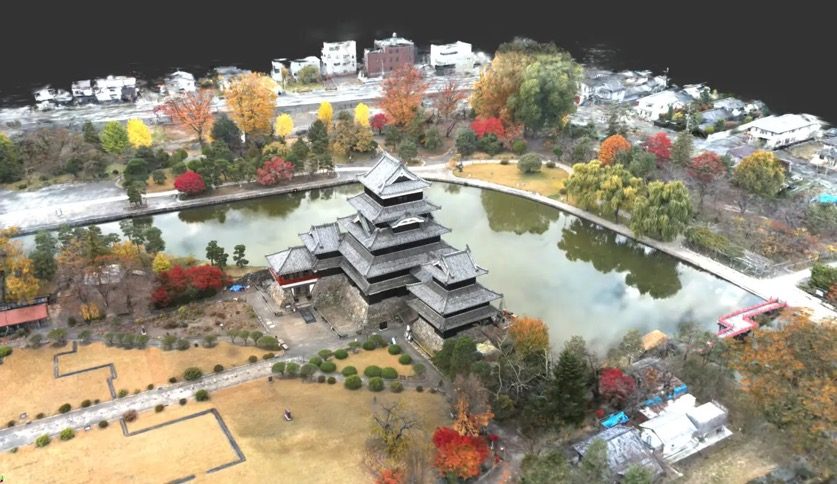 ドローン空撮と地上型レーザースキャンから作成した国宝松本城の3Dモデル。紅葉した樹木とお堀に囲まれた天守を斜め上から見た俯瞰