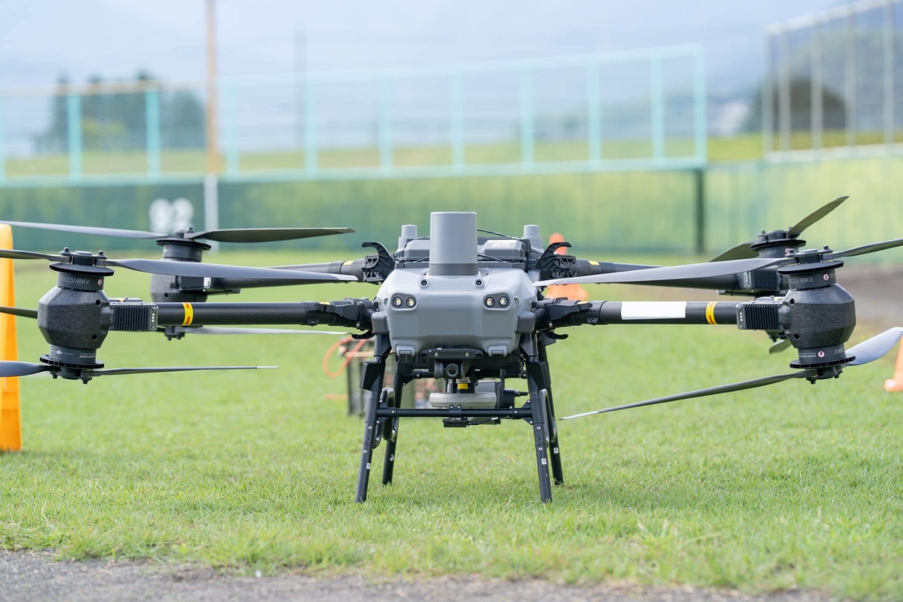 芝生の上に置かれたDJI FlyCart 30を正面から見たところ。4本のアームの先に、上下2枚ずつのプロペラが付いている