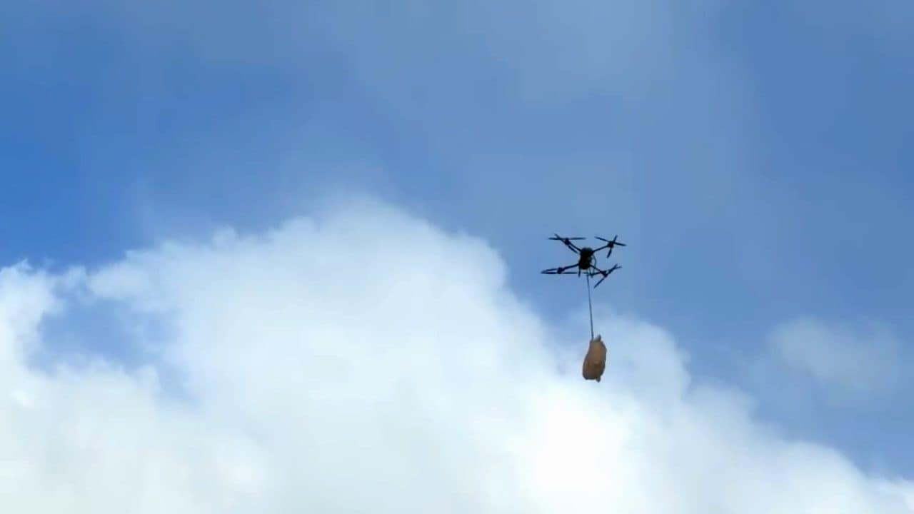 荷物を吊り下げて青空を飛ぶ物流ドローン DJI FlyCart 30