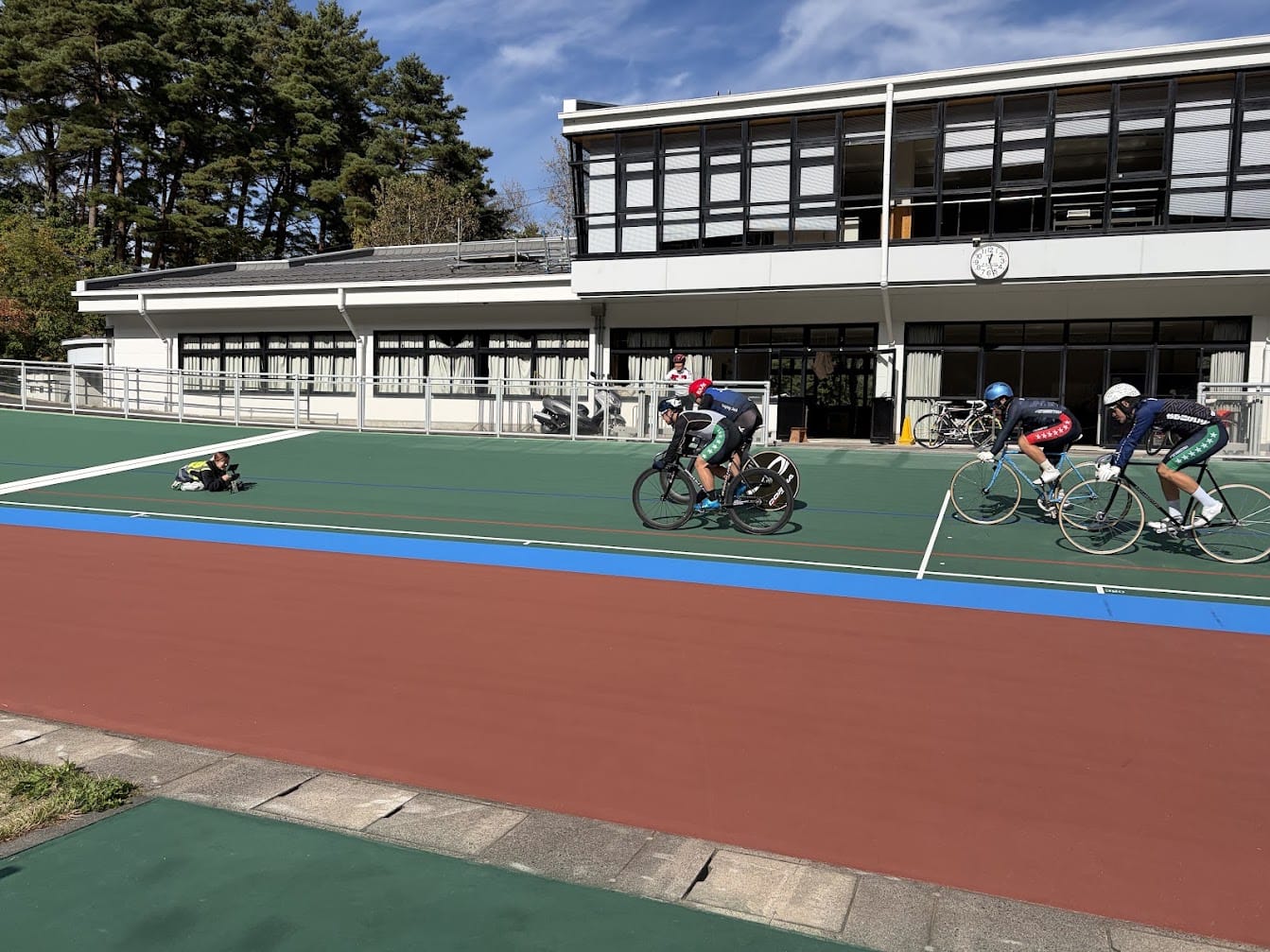 走路で撮影する当社スタッフと、その横を走る自転車競技の選手たち