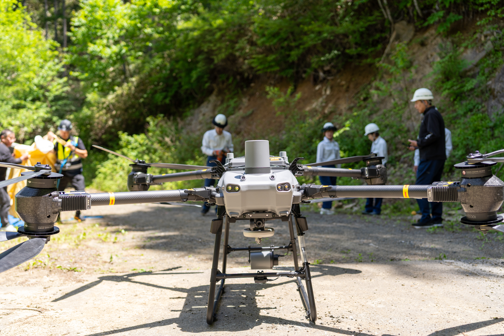長野県松本市奈川の実証現場に並ぶDJI FlyCart 30と参加者