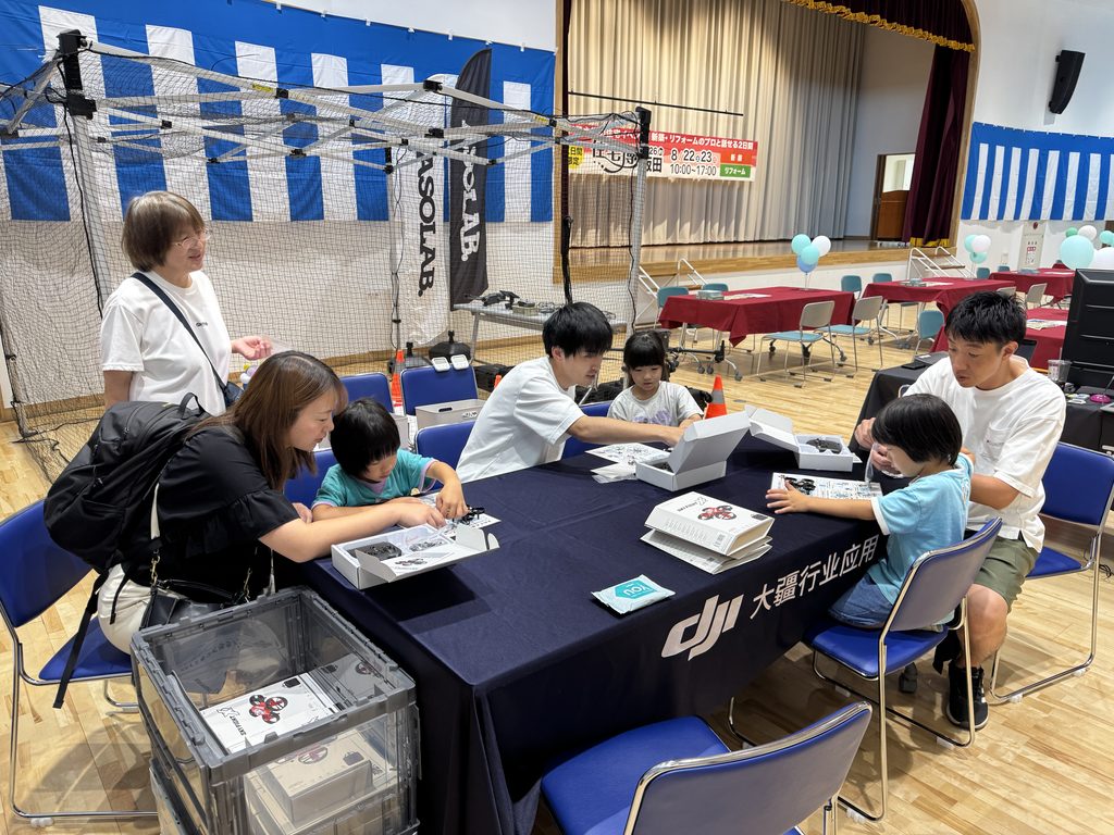 「住宅博 in 飯田」ASOLAB.ブースでトイドローンを組み立てる来場者
